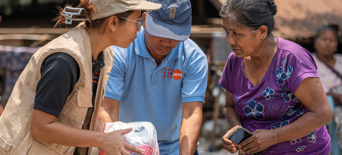 A woman affected by earthquake receives relief items including UNFPA's dignity kits during UN joint distribution in Sagaing, Myanmar. 